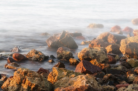 long exposure of sea and rocks and stones, teal tone, a Nature Photo by TanaCh