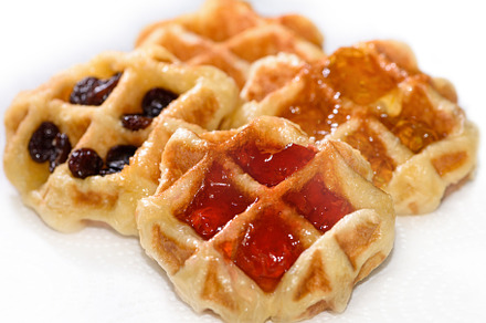 Many waffles with jam on white background