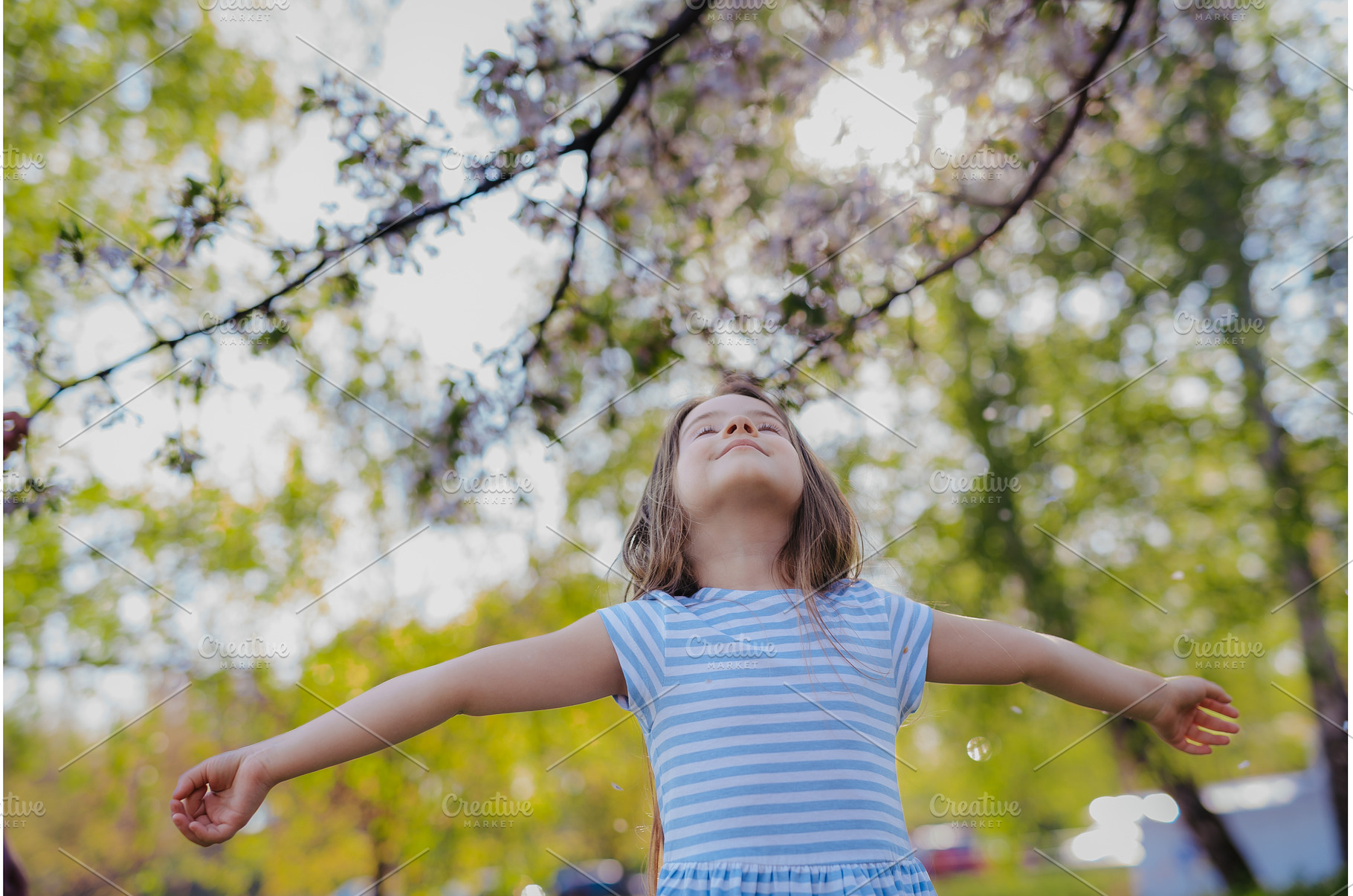 Young girl playing outside in spring, a Person Photo by HalfPoint