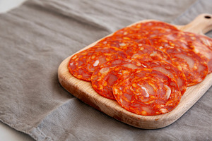 Cold Meat Chorizo Slices on a Wooden Board, side view. Close-up., a Food & Drink Photo by LiudmylaChuhunova
