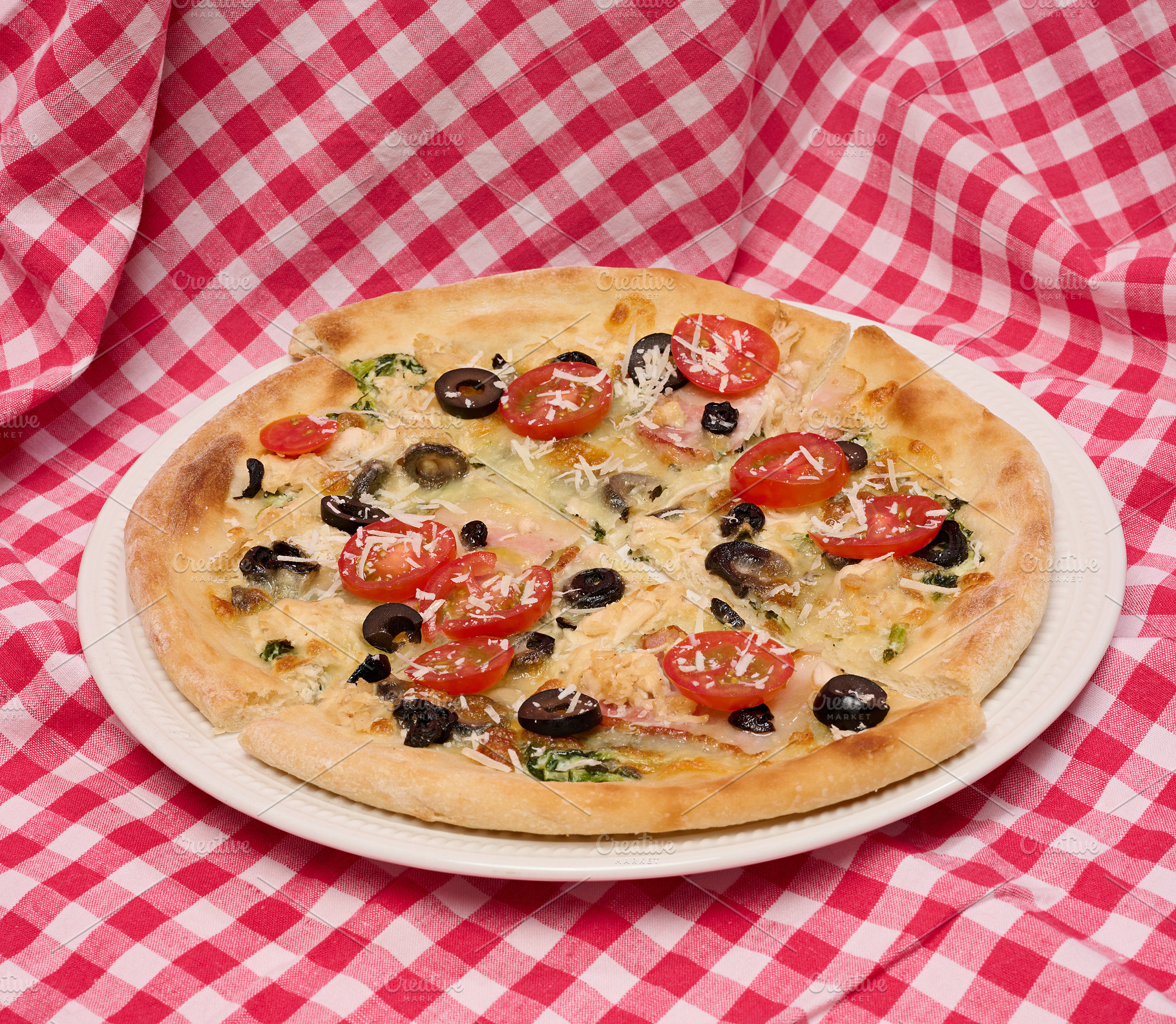 Pizza with cheese, tomatoes and olives on a white plate standing, a Food & Drink Photo by ndanko