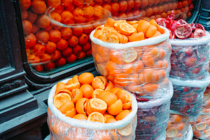 bags of squeezed oranges beside a shop window, a Photo by Nito