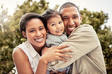 Hug, child and parents with smile in a park for love, care and adventure on a holiday in Maldives. Happy, travel and portrait of mother and father hugging kid while on vacation in a nature garden, a Photo by Peopleimages.com