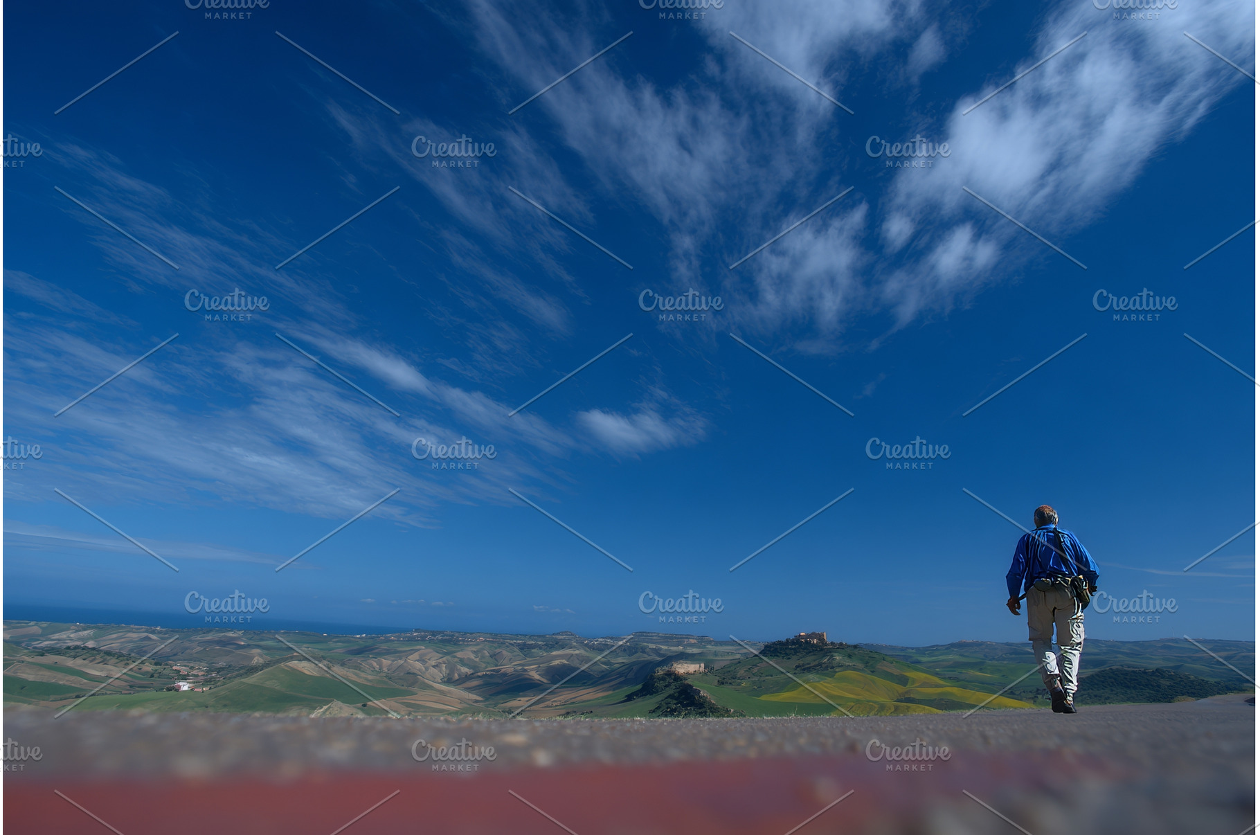 A man is walking on a road during a, a Nature Photo by ZinetroN