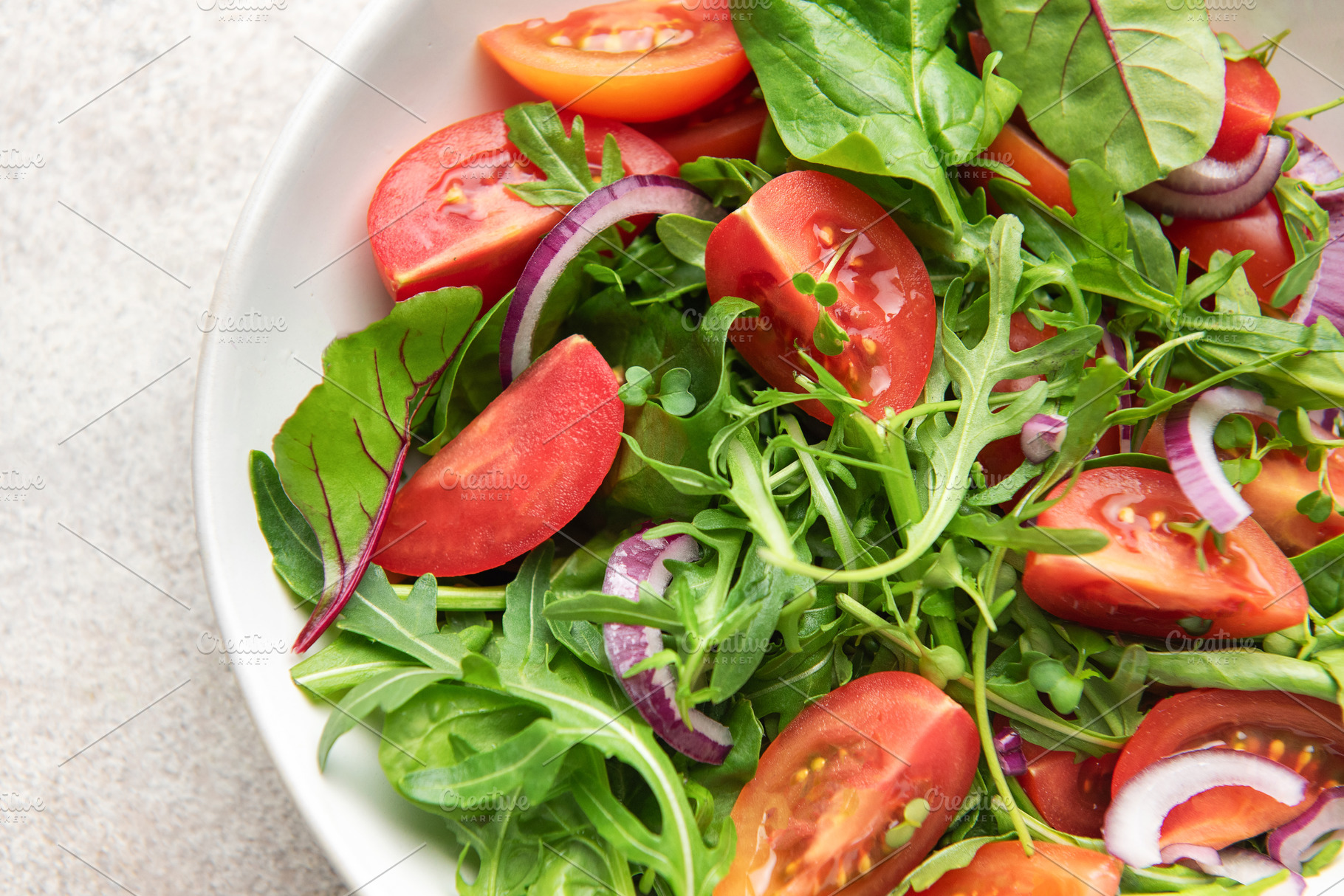 Fresh vegetable salad with arugula, tomatoes, and red onion, a Photo by Olena Rudo