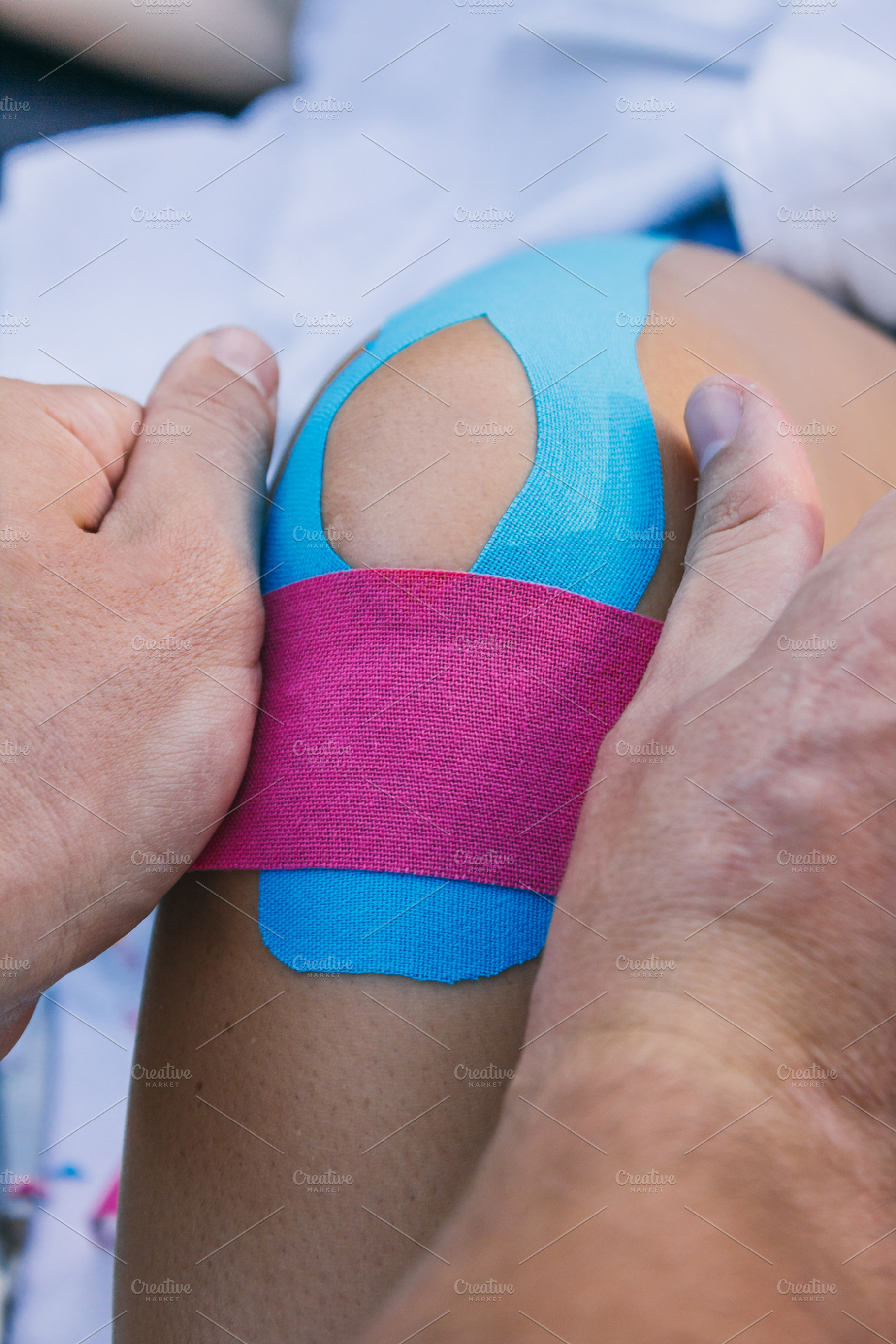 Physiotherapist putting kinesiotape stock photo containing aching and adhesive, a Health & Medical Photo by Am.Benitez Estudio
