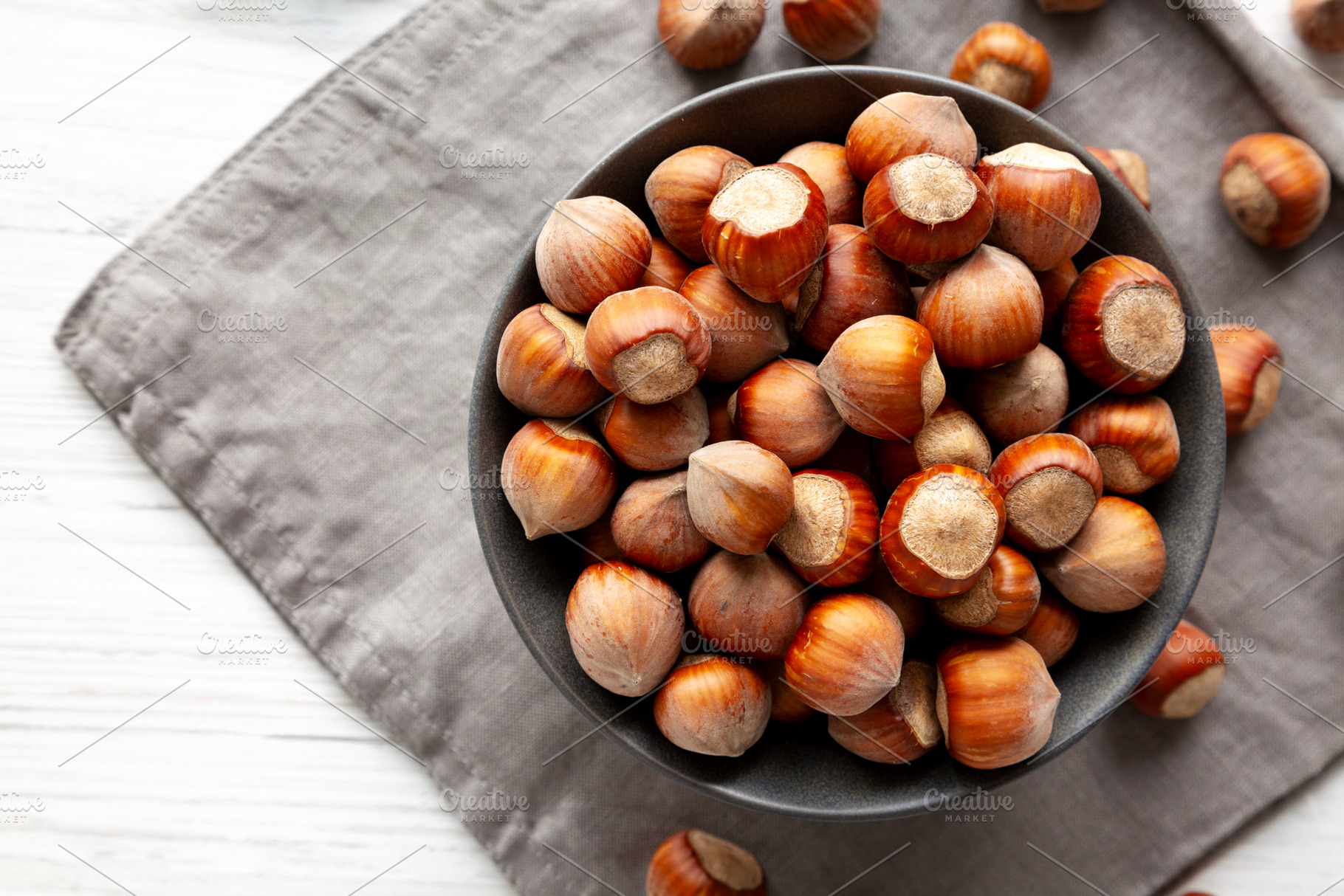 Organic Raw Hazelnuts in a Bowl, top view. Space for text., a Food & Drink Photo by LiudmylaChuhunova