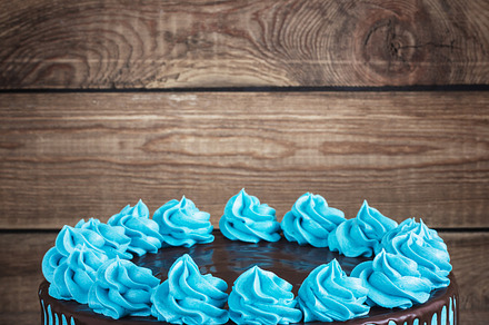 Birthday cake with cream chocolate drips on a dark wooden background stock