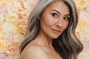 Smiling mature topless woman standing posing