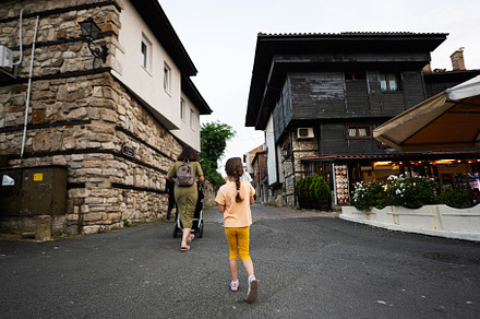 Back view of mother and daughter walking in the street of old to, a Person Photo by AS photostudio