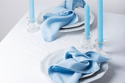 Blu linen napkins and blu candles on the white table
