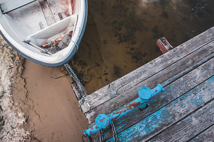Old boat on an old wooden blue wharf on a river-lake. Top view,, a Transportation Photo by TanaCh