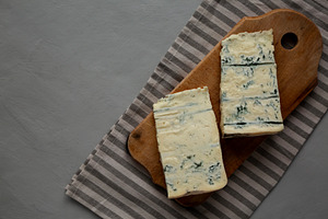 Blue cheese Gorgonzola on a Wooden Board, top view. Space for te, a Food & Drink Photo by LiudmylaChuhunova