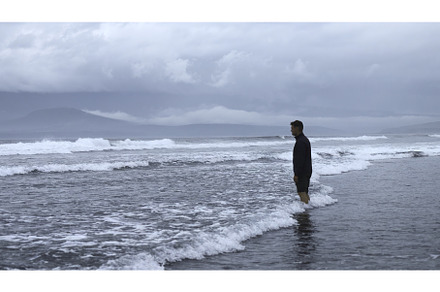 Man stands on water on seashore in, a Person Photo by Media Whale Stock
