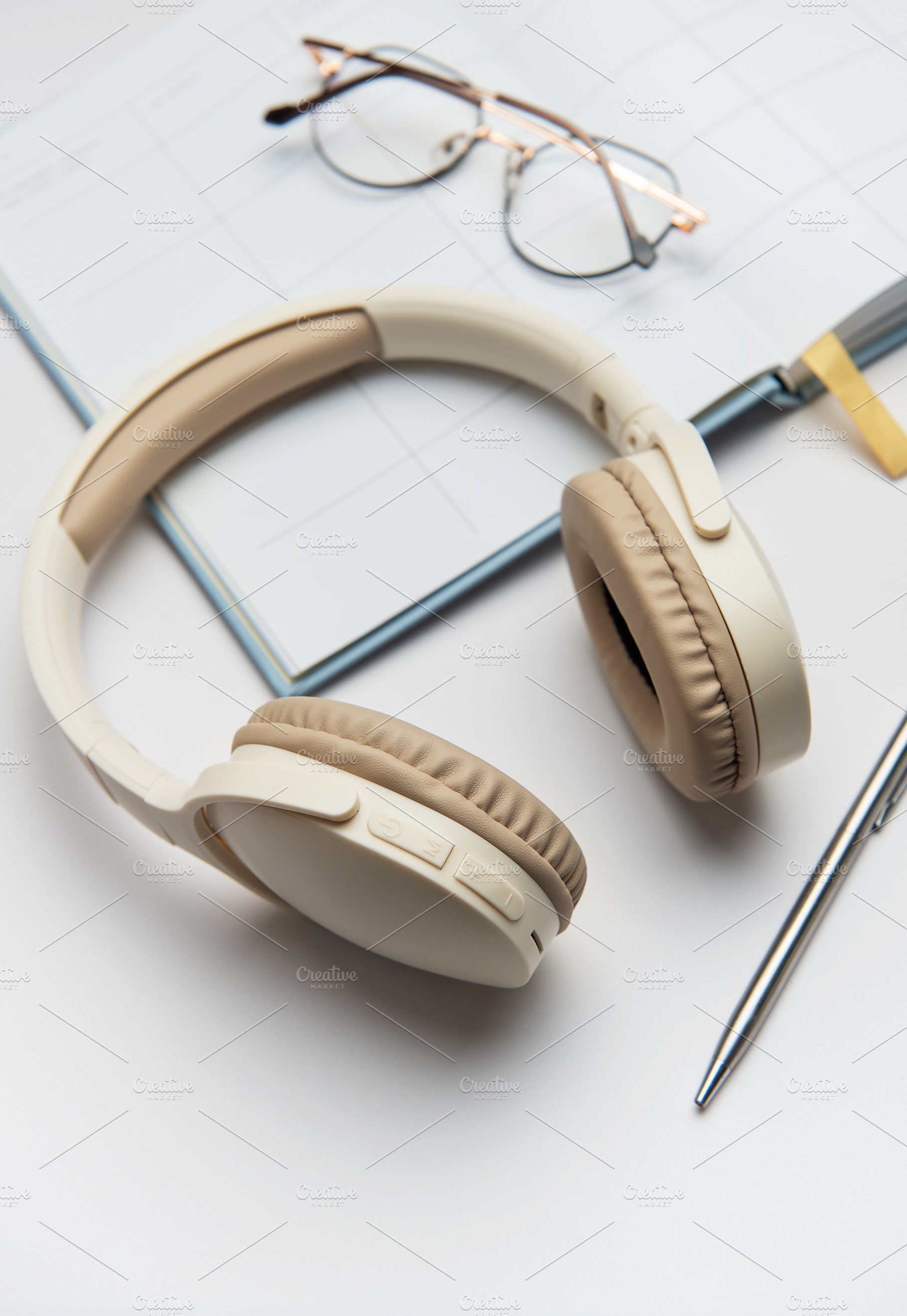 Wireless headphones, planner, eyeglasses and pen lying on white, a Technology Photo by Olena Rudo