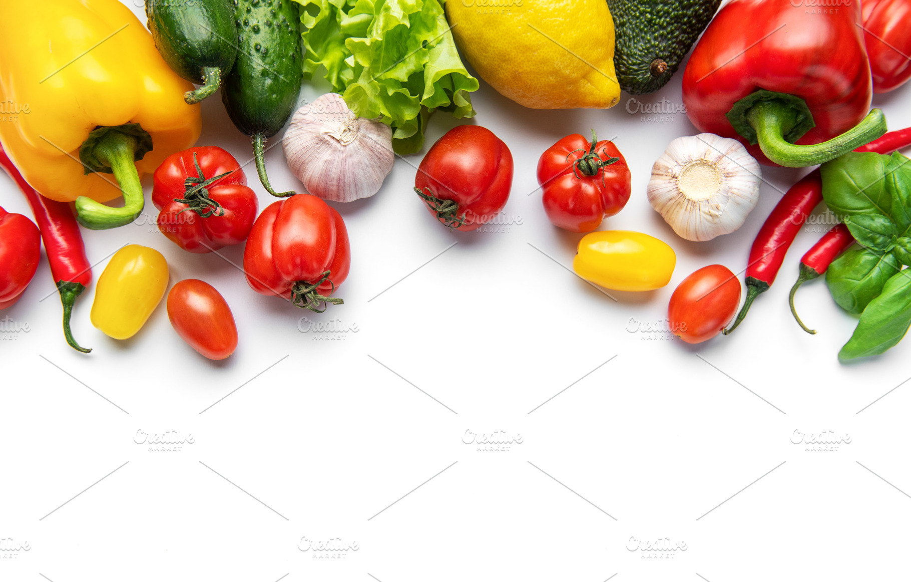 Fresh vibrant farm vegetables forming border on white, a Food & Drink Photo by Olena Rudo