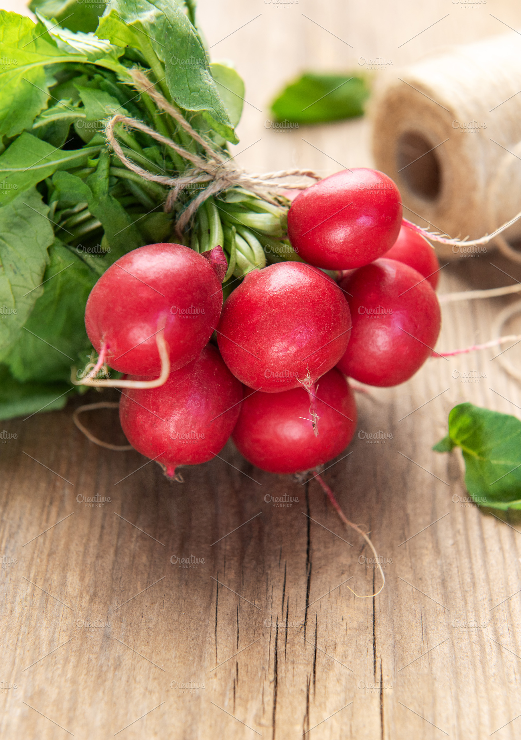 Fresh organic radishes with green leaves on wood, a Food & Drink Photo by Olena Rudo