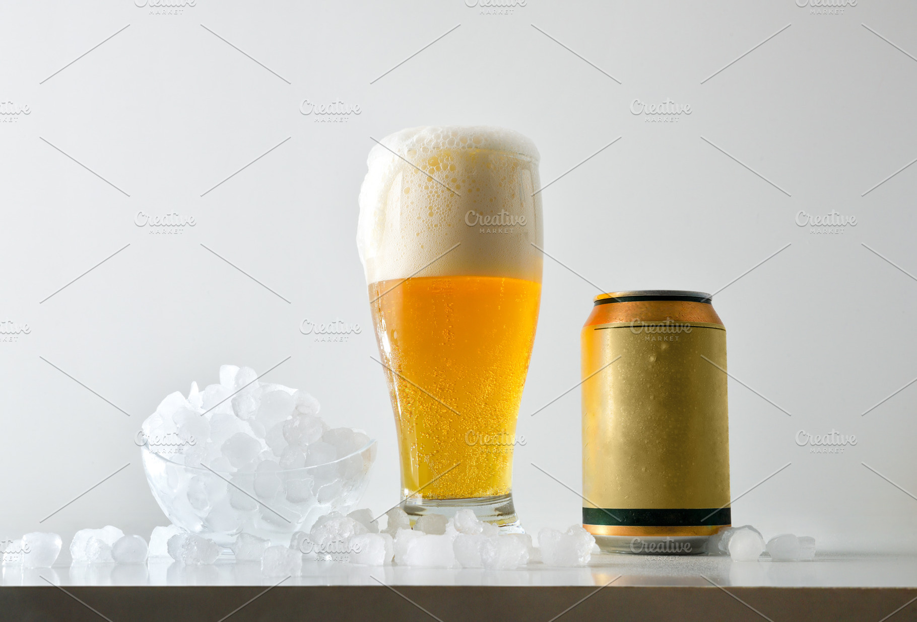 Foamy beer and can on table with ice cubes, a Food & Drink Photo by Davizro's Market