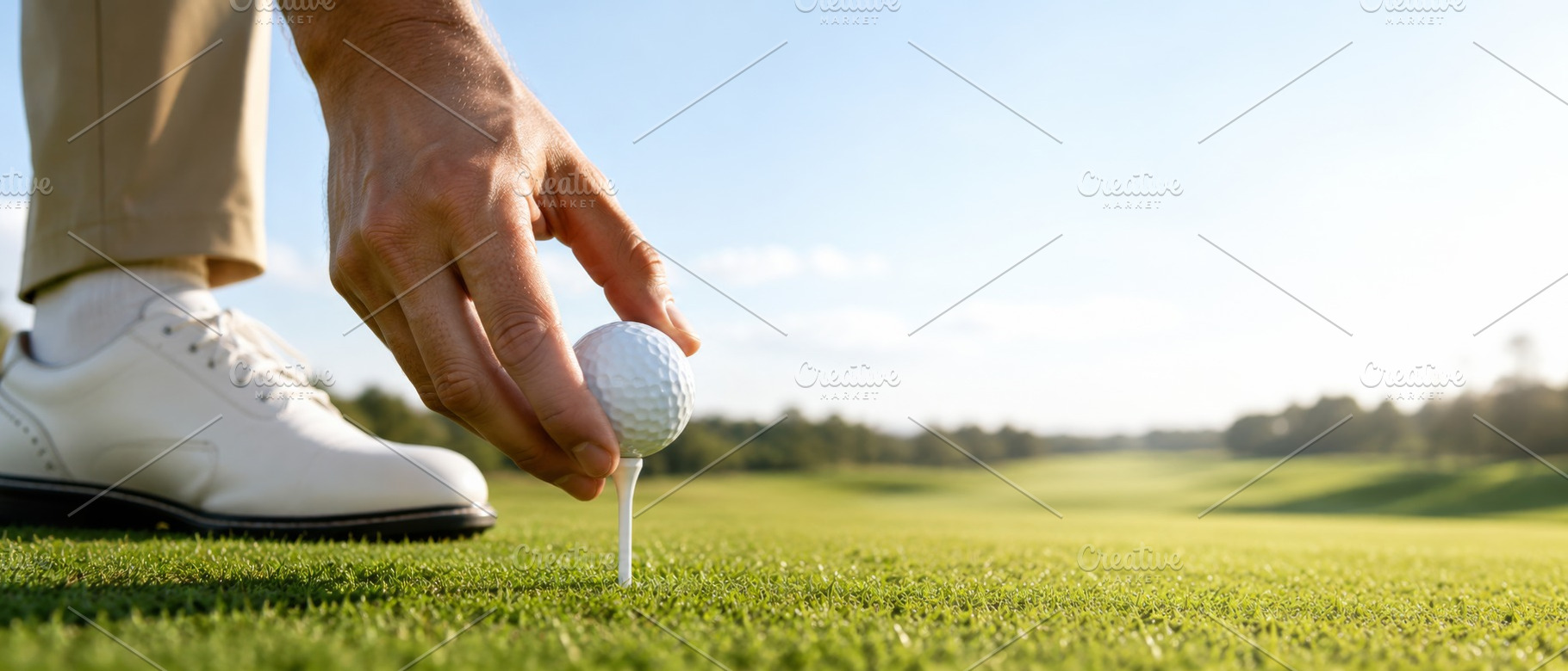 Golf player placing ball on tee with, a Photo by Dvoevnore photos