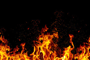 Bright orange flames and sparks on black background, an Abstract Photo by ndanko