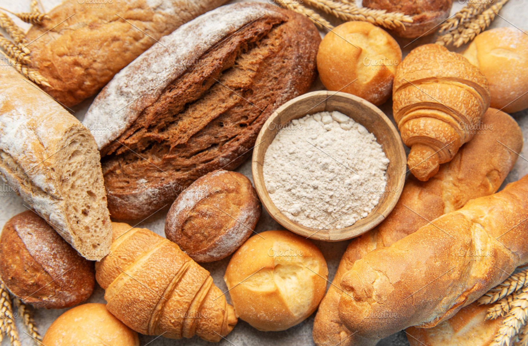 Freshly baked bread and pastries with baking flour, a Food & Drink Photo by Olena Rudo