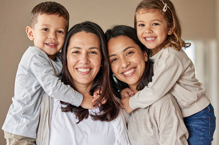 Diverse family smiling and hugging in a natural home setting, a Person Photo by DanFLCreativo