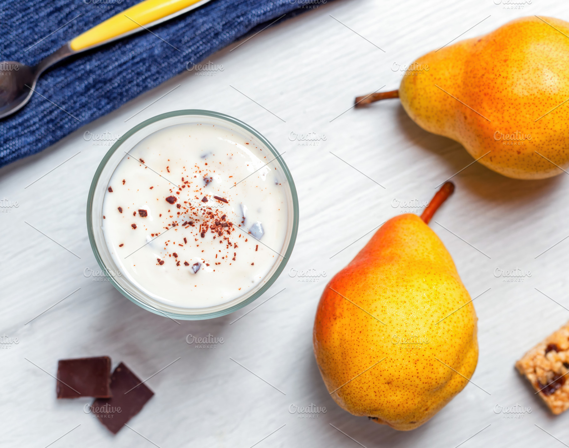 Yogurt with grated chocolate and pears on white wooden table enjoying a healthy, a Food & Drink Photo by Antonio Gravante Market
