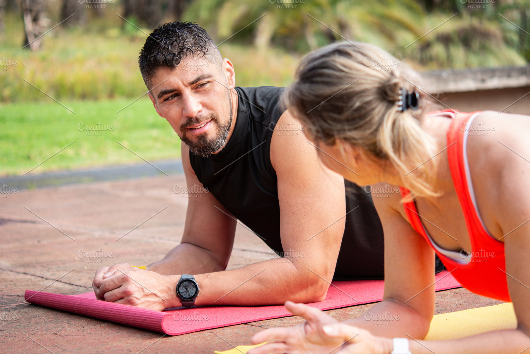 Personal trainer guiding woman during plank exercise outdoors,, a Person Photo by etorres69