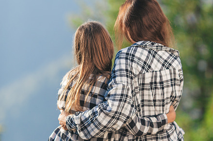 Back view of mother and her daughter sit on a terrace at a height in the mounta, a Person Photo by travnikovstudio