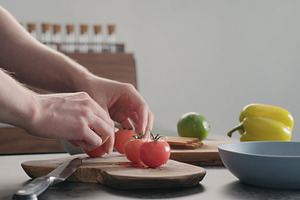 Man Put Tomatoes On Olive Wood Board