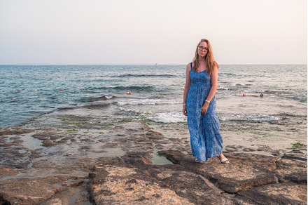 Woman sits on the beach and looks at, a Person Photo by Jan Jack Russo Media