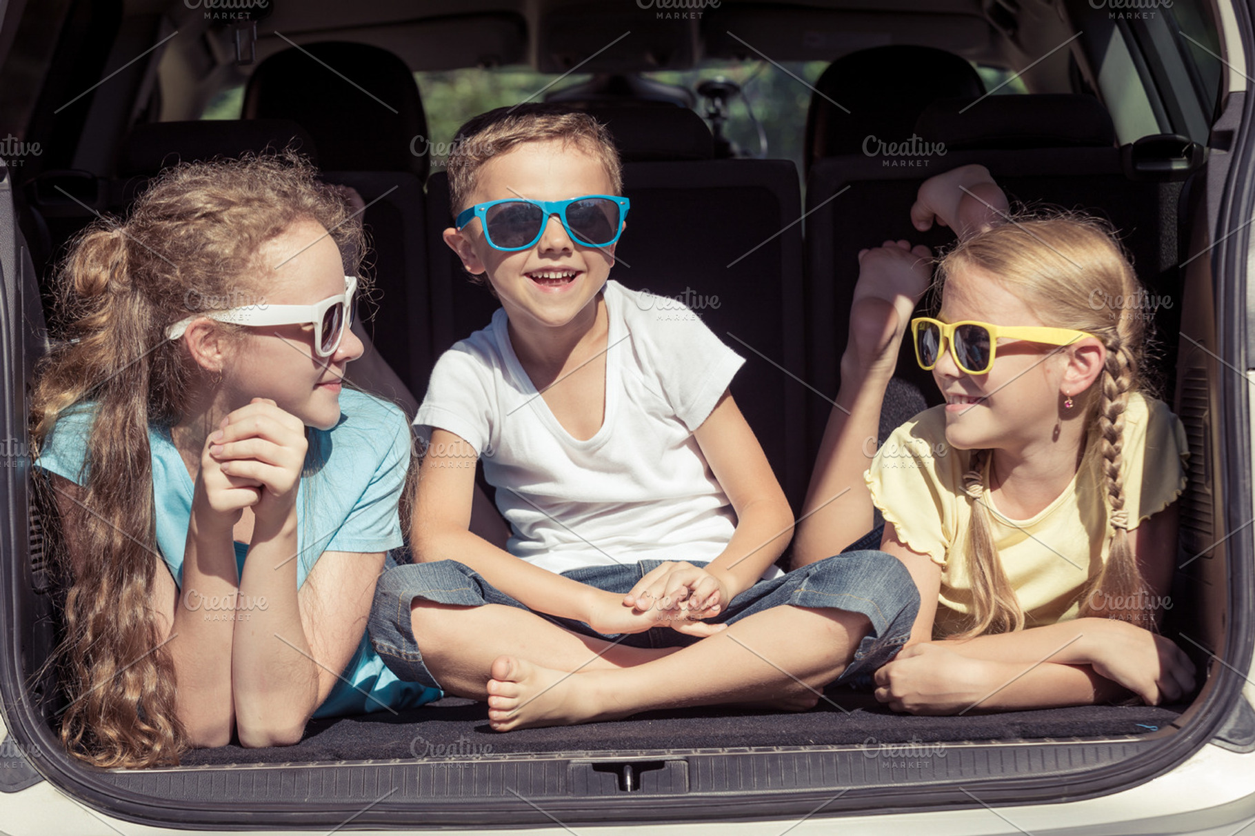 Happy kids sitting in the car containing car, child, and family, a Transportation Photo by altanaka