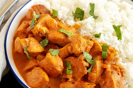 Homemade Easy Indian Butter Chicken with Rice on a Plate on a bl, a Food & Drink Photo by LiudmylaChuhunova