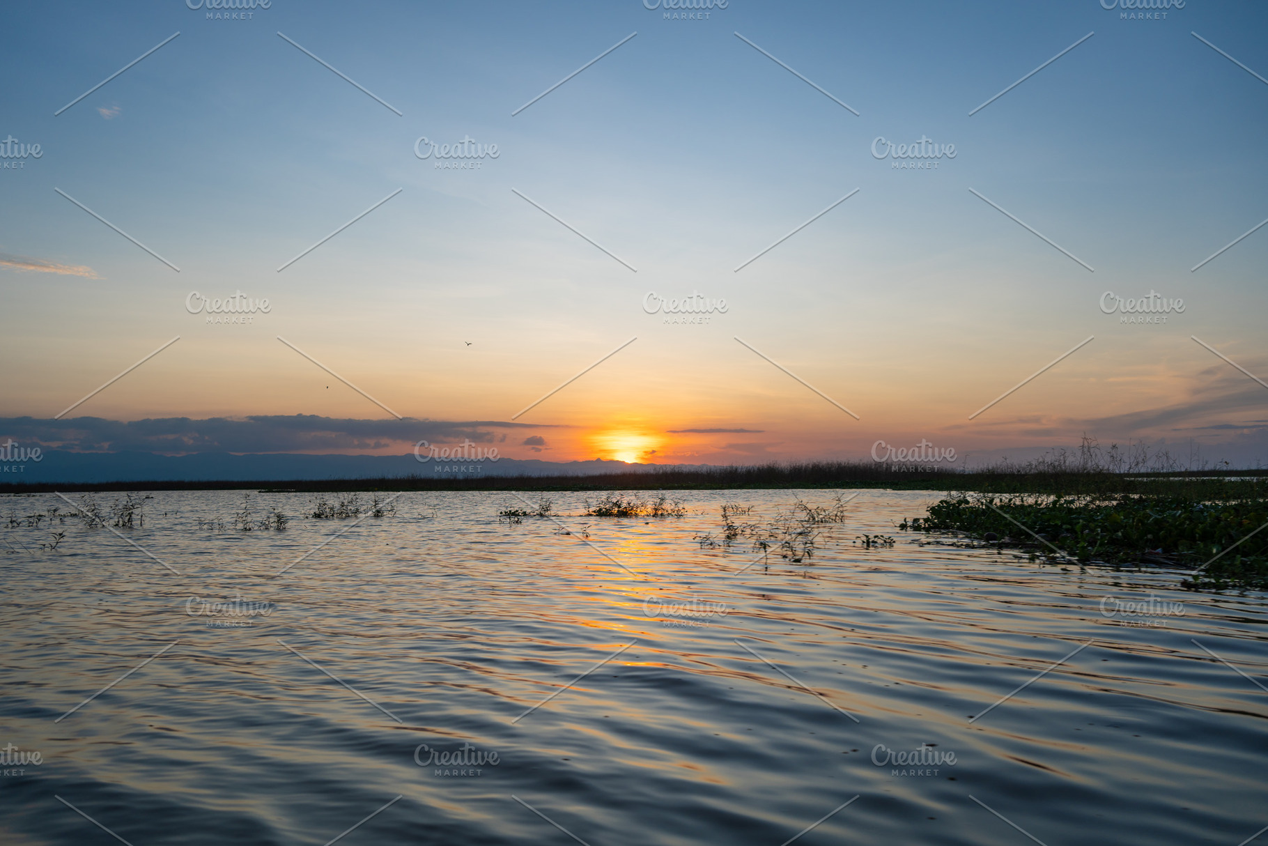 Sunset over Lake Tempe in Sulawesi, Indonesia's peaceful waters, a Nature Photo by GoodGoods