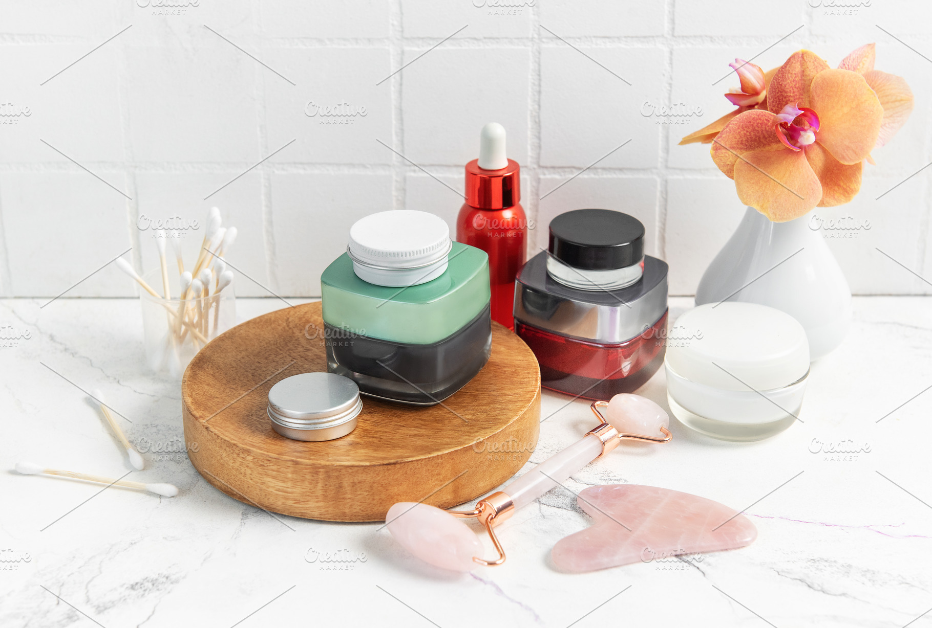 Skincare product bottles with jade roller and orchid, a Beauty & Fashion Photo by Olena Rudo