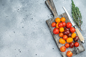 Colorful mix of cherry tomatoes on a rustic wooden board with he, a Food & Drink Photo by composter-box@mail.ru