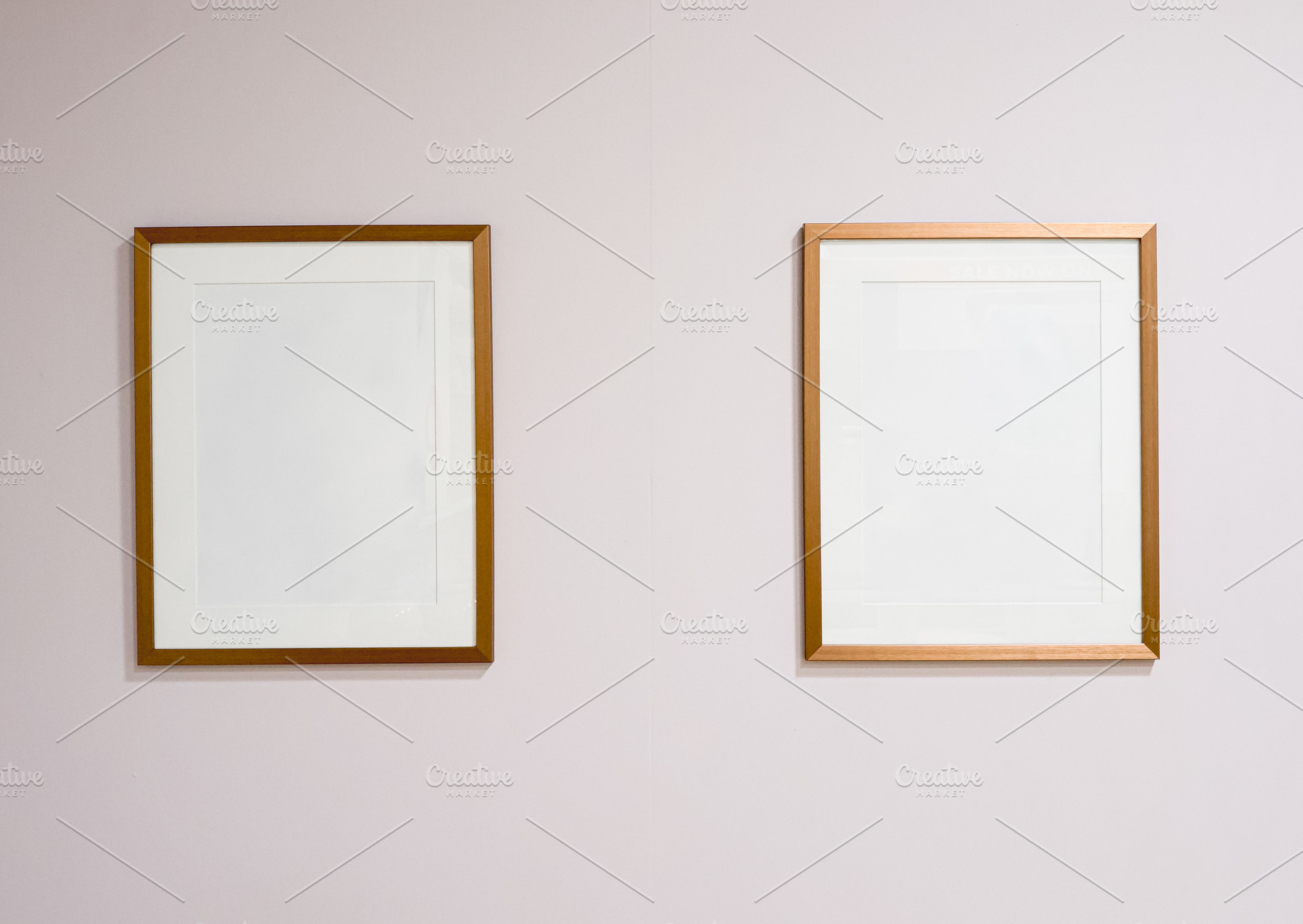 Two empty golden picture frames hanging on a blank wall, presenting a simple ar, a Photo by Studio ANNA