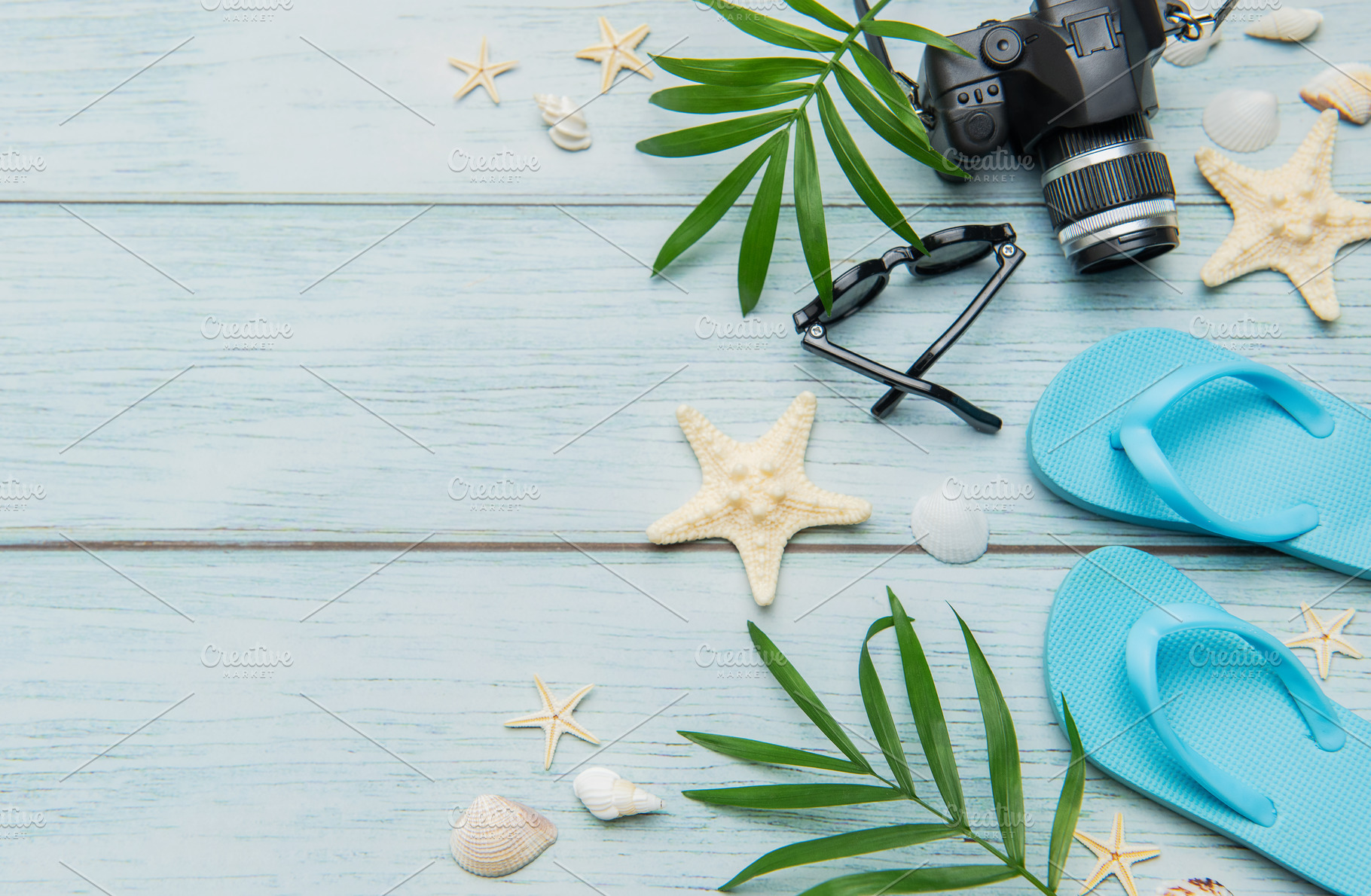 Beach vacation accessories arranged on rustic blue wooden backgr, a Holiday Photo by Olena Rudo