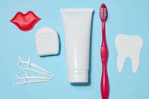 Tube of toothpaste, dental floss, red toothbrush, decorative red, a Health & Medical Photo by ndanko