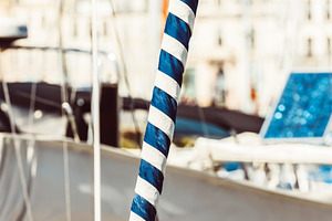 Sailboat mast with blue and white st, a Photo by Dvoevnore photos