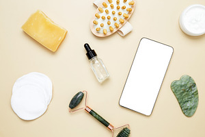 Smartphone mockup with skincare products including marble face roller, gua sha,, a Photo by matucha