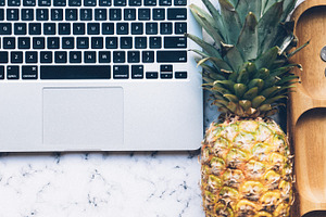 Flat lay on marble with pineapple featuring flat lay, marble, and laptop
