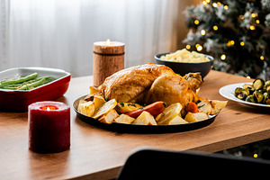 Whole roasted chicken with potatoes and vegetables.