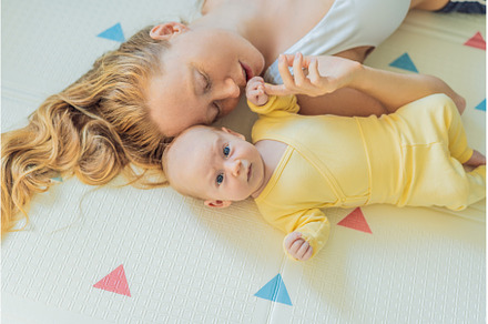 Mother and baby lying on a play mat