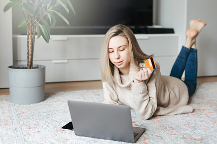 Young woman holding credit card and using laptop computer., a Business Photo by Olena Rudo