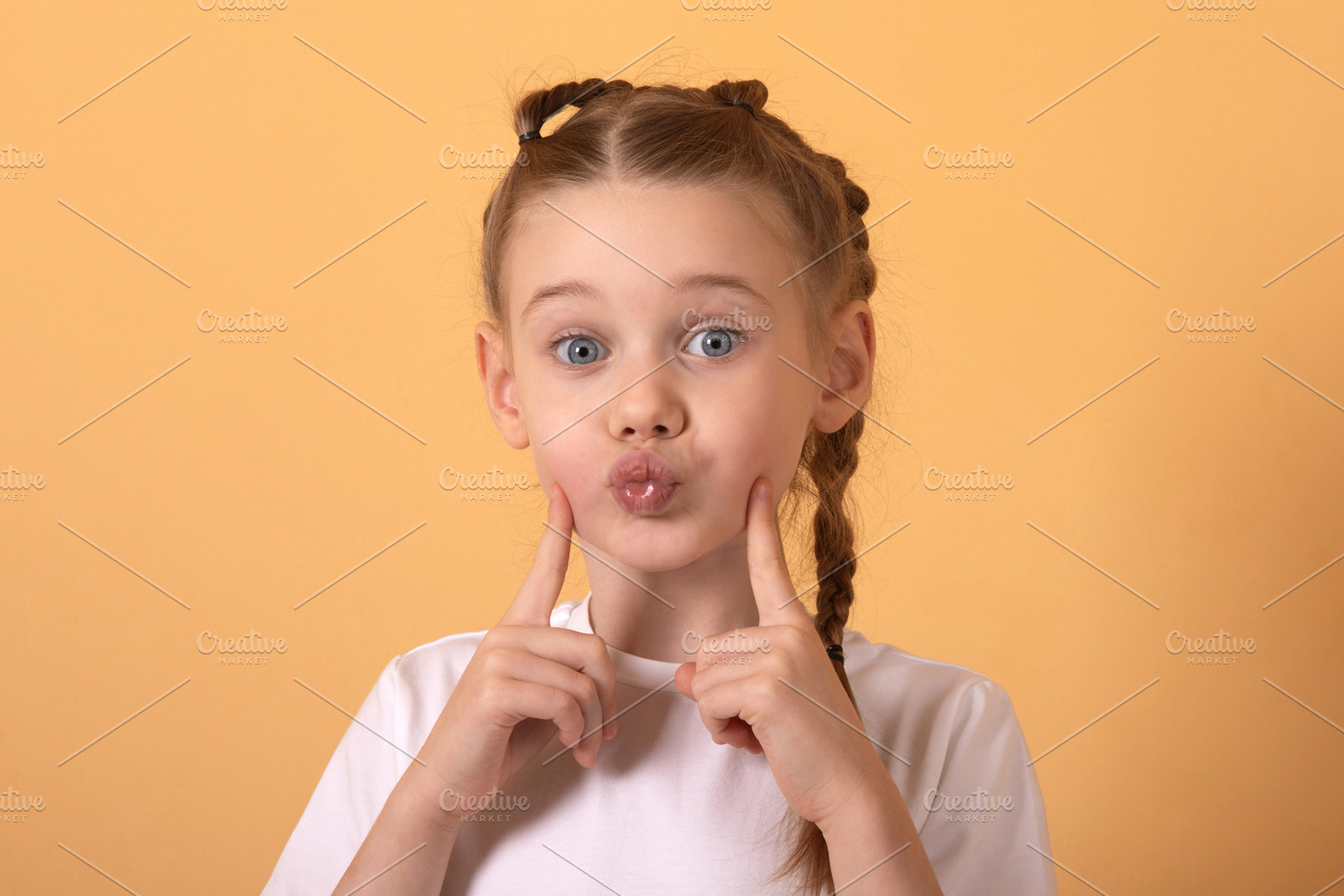 Cheerful young girl with braided hair making a funny face agains, a Person Photo by Ales Munt