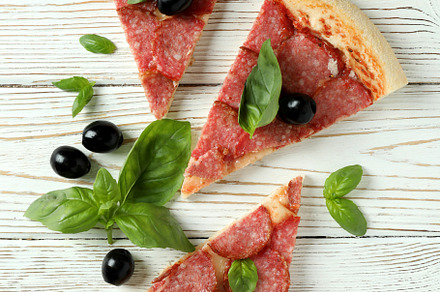 Slices of Salami pizza on white wooden background, a Food & Drink Photo by AtlasStudio PRO