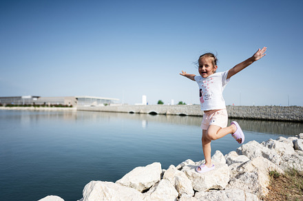 Joyful little girl playing by the lake on a sunny day in Nin, Croatia., a Person Photo by AS photostudio