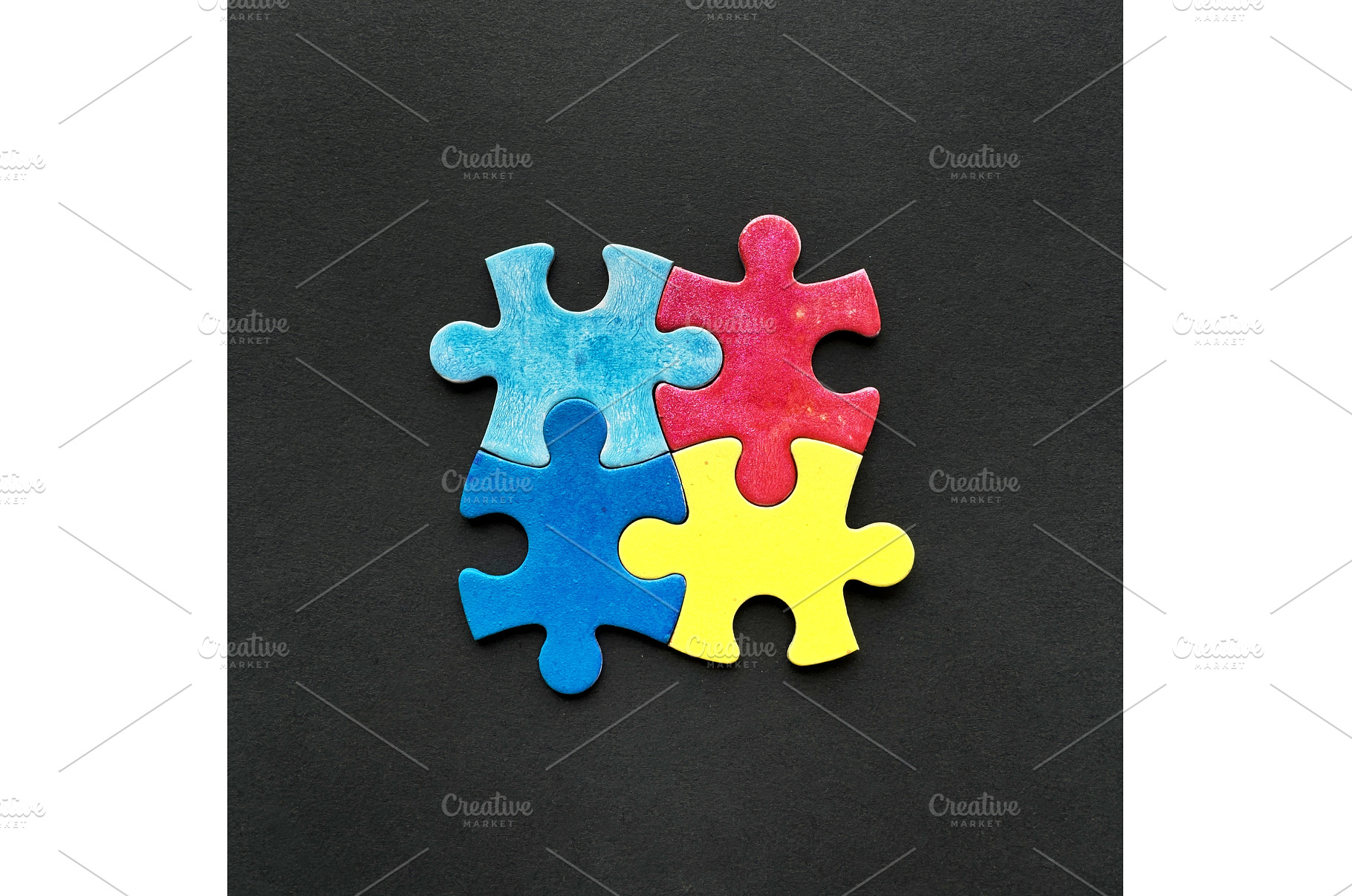 Four colorful puzzle pieces in red, a Photo by tilialucida