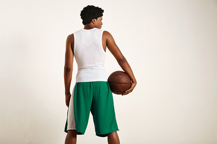 Back of a muscular black athlete holding  leather basketball featuring ball, a Sports & Recreation Photo by DeRepente